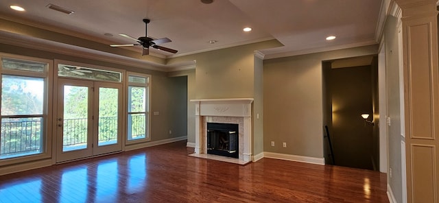 unfurnished living room with visible vents, baseboards, ornamental molding, a premium fireplace, and wood finished floors