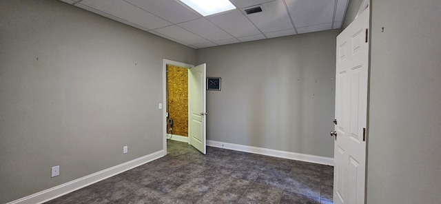 spare room with visible vents, a paneled ceiling, and baseboards