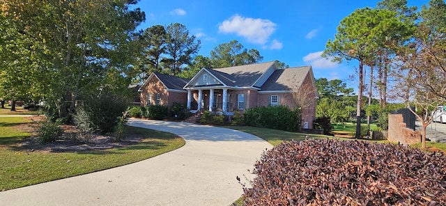 neoclassical home with concrete driveway and a front lawn