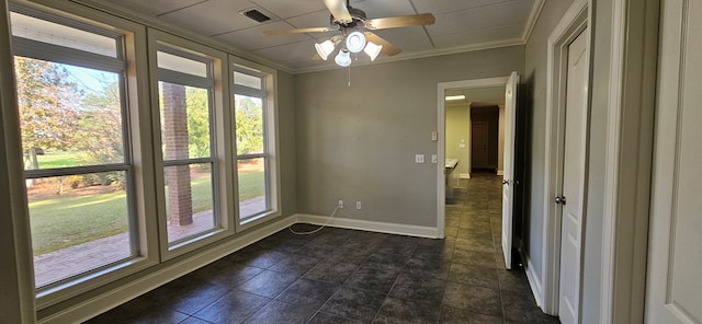 empty room featuring plenty of natural light, baseboards, visible vents, and ornamental molding