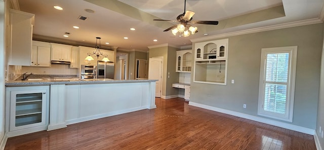 kitchen featuring visible vents, a peninsula, a sink, wine cooler, and stainless steel fridge