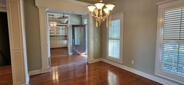 unfurnished dining area featuring a chandelier, baseboards, and dark wood-style flooring