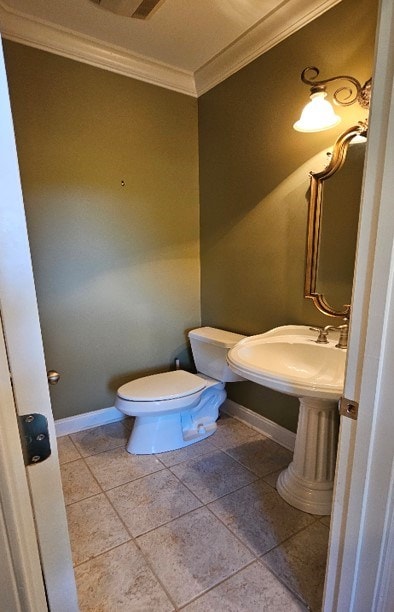 half bath featuring baseboards, toilet, crown molding, and tile patterned flooring