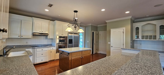 kitchen with visible vents, a sink, dark wood-type flooring, under cabinet range hood, and appliances with stainless steel finishes