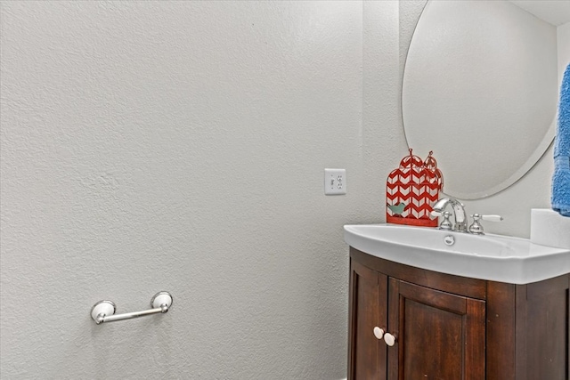 bathroom with a textured wall and vanity