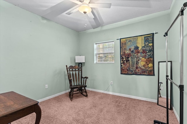 sitting room with carpet floors, baseboards, and a ceiling fan