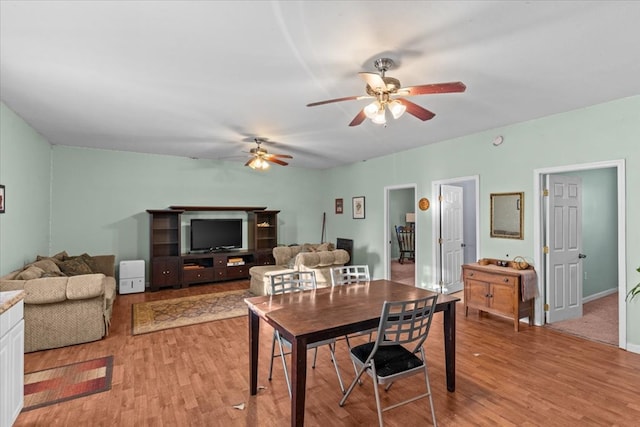 dining area with light wood-style floors and ceiling fan