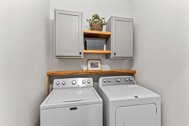 washroom with cabinet space and washer and clothes dryer