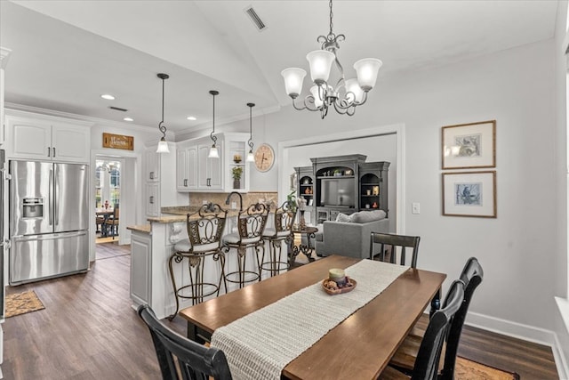 dining room with visible vents, baseboards, ornamental molding, dark wood-type flooring, and a chandelier