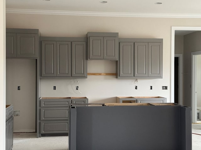 kitchen with gray cabinets, light colored carpet, and ornamental molding