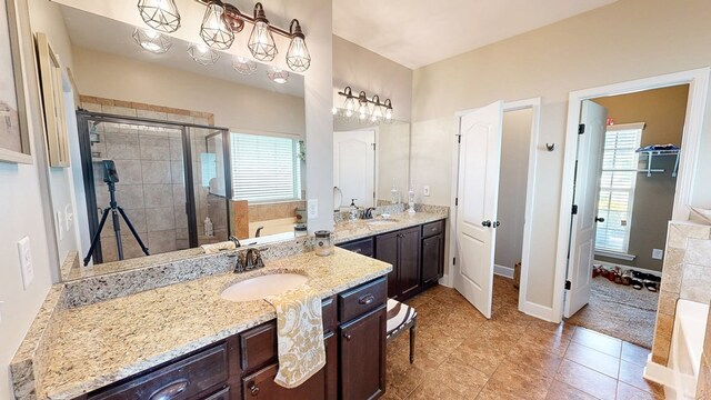 bathroom with baseboards, a sink, a stall shower, and two vanities