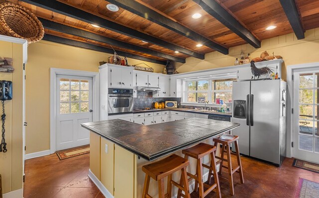 kitchen with a center island, stainless steel appliances, white cabinetry, and plenty of natural light