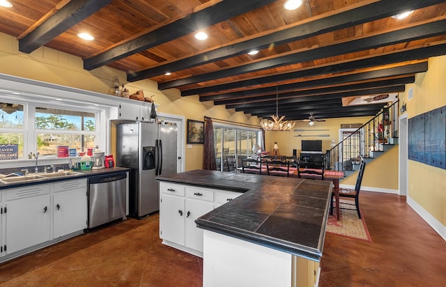 kitchen with ceiling fan, sink, white cabinets, a kitchen island, and appliances with stainless steel finishes