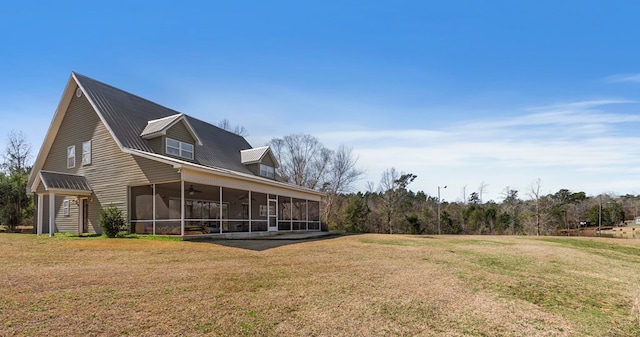 rear view of house with a sunroom and a yard