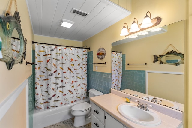 full bathroom featuring vanity, shower / tub combo with curtain, tile walls, tile patterned flooring, and toilet