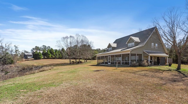 view of home's exterior with a sunroom and a yard