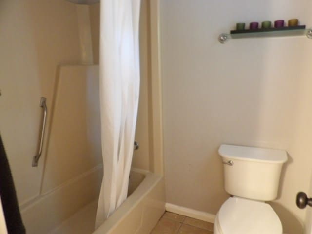 bathroom with toilet, tile patterned floors, and shower / bath combo