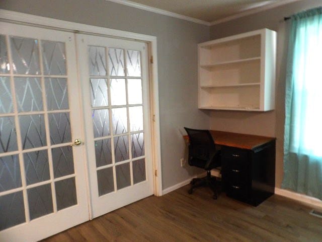 unfurnished office featuring french doors, dark hardwood / wood-style flooring, and crown molding