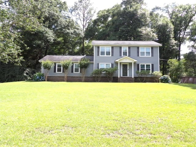 colonial inspired home with a front lawn