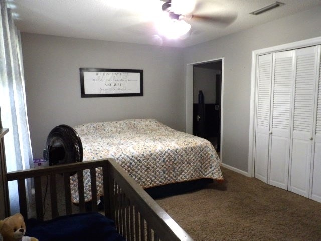 bedroom with a closet, ceiling fan, and carpet floors