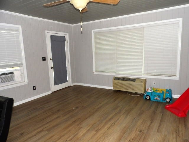 playroom with a wall mounted AC, ceiling fan, cooling unit, dark hardwood / wood-style flooring, and ornamental molding