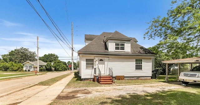 view of front of property featuring entry steps, roof with shingles, and a front lawn