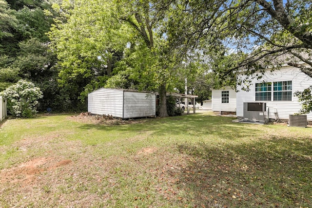 view of yard featuring central air condition unit, a storage unit, and an outbuilding