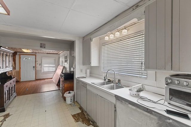 kitchen featuring light countertops, a toaster, light floors, and a sink