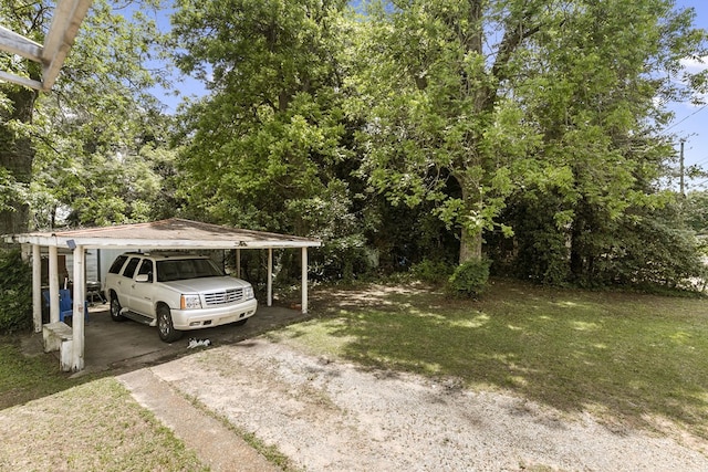 view of parking featuring dirt driveway and a carport