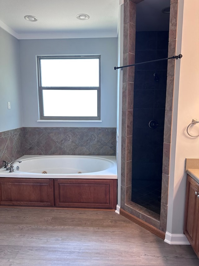 183 Chestnutt Rd, Slocomb, AL 36375 - full bath featuring vanity, a whirlpool tub, wood finished floors, a shower stall, and ornamental molding