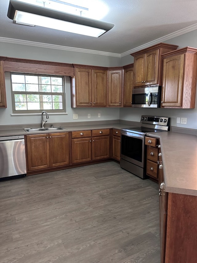 183 Chestnutt Rd, Slocomb, AL 36375 - kitchen with stainless steel appliances, ornamental molding, brown cabinets, and light wood-type flooring