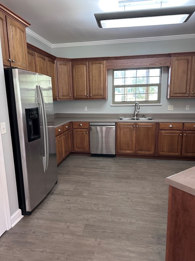 183 Chestnutt Rd, Slocomb, AL 36375 - kitchen with stainless steel appliances, crown molding, wood finished floors, brown cabinets, and light countertops