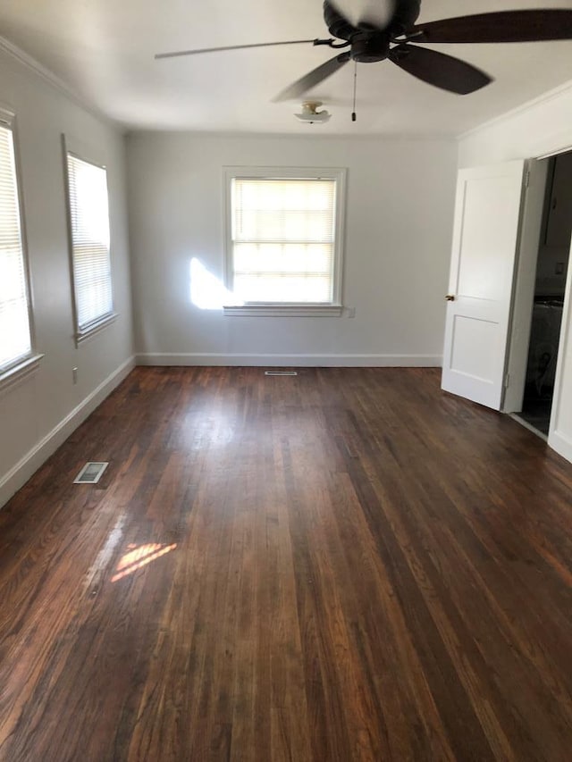 spare room with plenty of natural light, ceiling fan, and dark hardwood / wood-style flooring