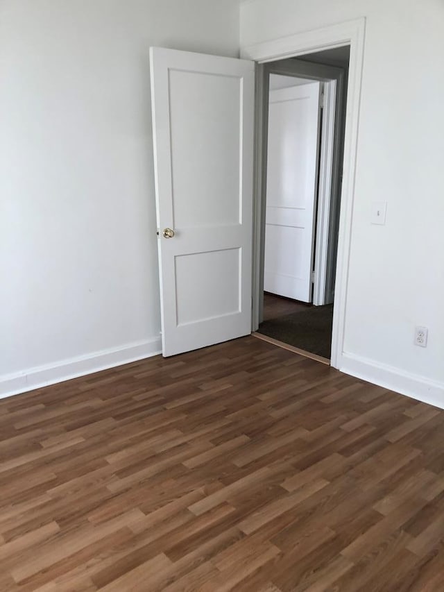 spare room featuring dark wood-type flooring