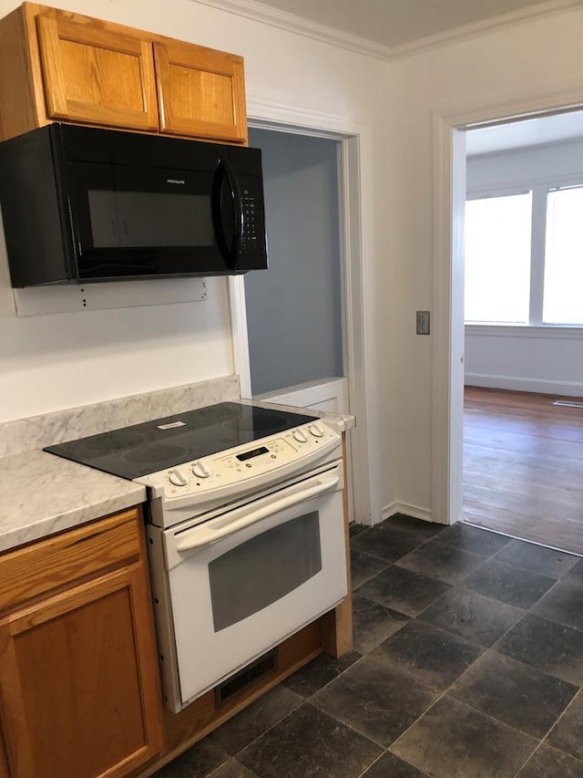 kitchen with dark hardwood / wood-style flooring, electric range, and ornamental molding