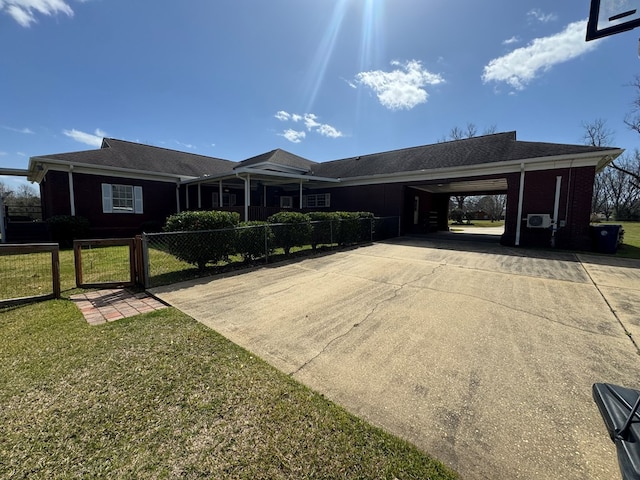 ranch-style home with driveway, a fenced front yard, a gate, a front lawn, and a carport