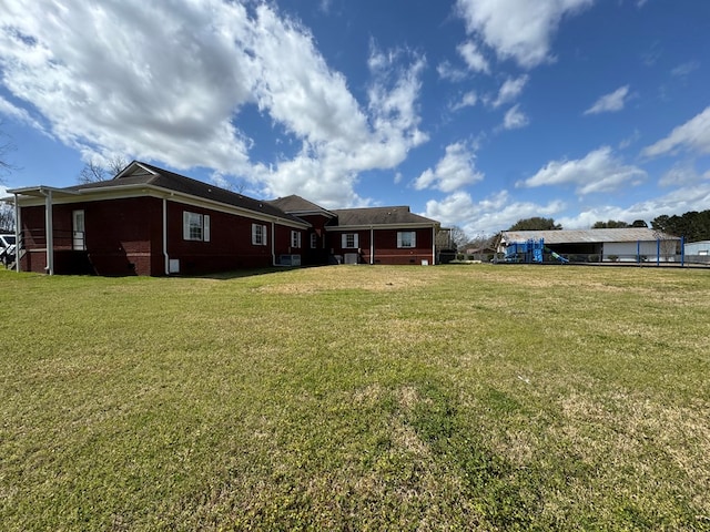 rear view of property featuring a lawn