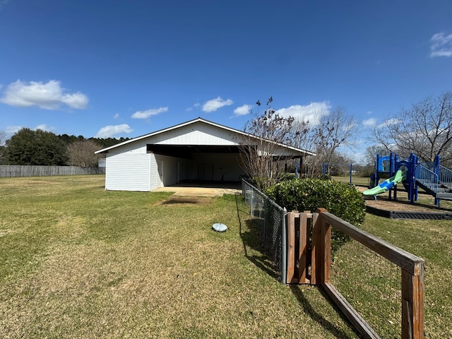 exterior space with fence, a playground, and a yard