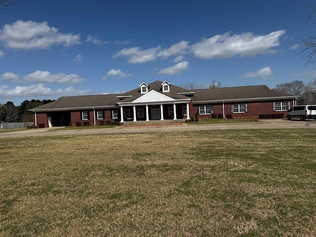 view of front of home with a front yard and brick siding