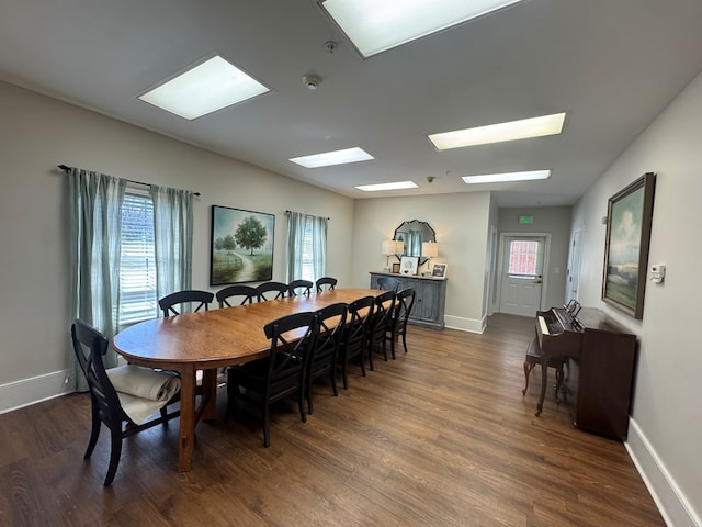 dining area with baseboards and dark wood-style flooring