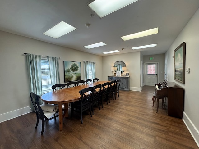 dining space with dark wood finished floors and baseboards