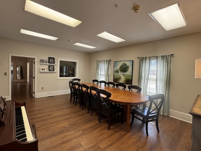 dining space with visible vents, baseboards, and dark wood finished floors