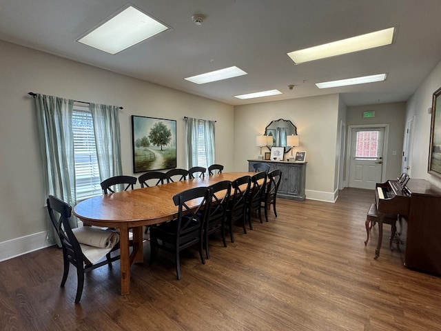 dining space with baseboards and wood finished floors