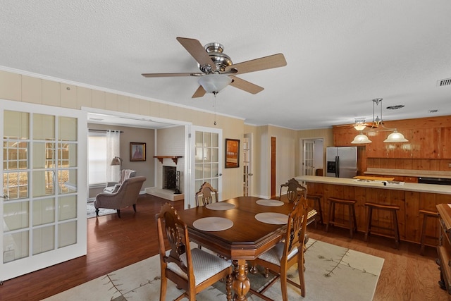 dining space featuring dark hardwood / wood-style flooring, ceiling fan, and crown molding