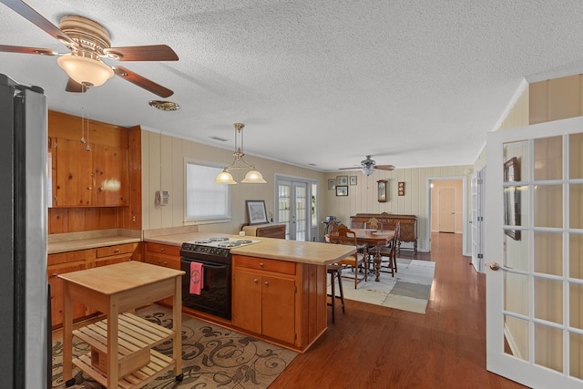 kitchen featuring french doors, kitchen peninsula, black range with electric cooktop, stainless steel fridge, and crown molding