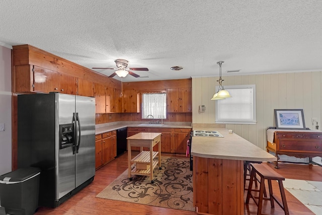 kitchen featuring dishwasher, decorative light fixtures, stainless steel fridge, ceiling fan, and sink