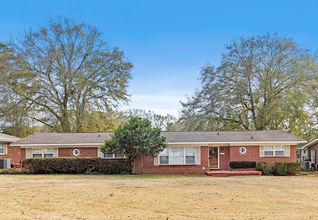 ranch-style house with central AC unit and a front lawn