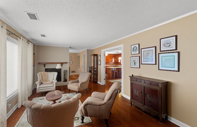 living area featuring ornamental molding, hardwood / wood-style floors, and a textured ceiling