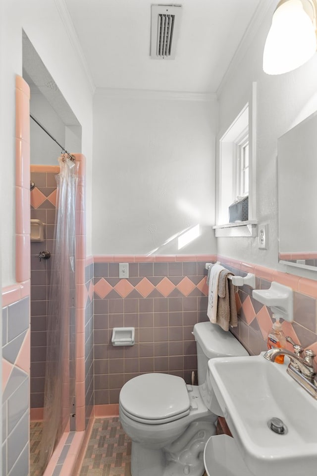 bathroom with sink, tile walls, toilet, walk in shower, and crown molding