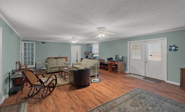 living room with ornamental molding, french doors, a textured ceiling, and wood-type flooring